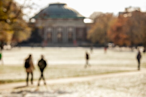 Abstract view of snow-covered Quad in late fall with students walking to class.